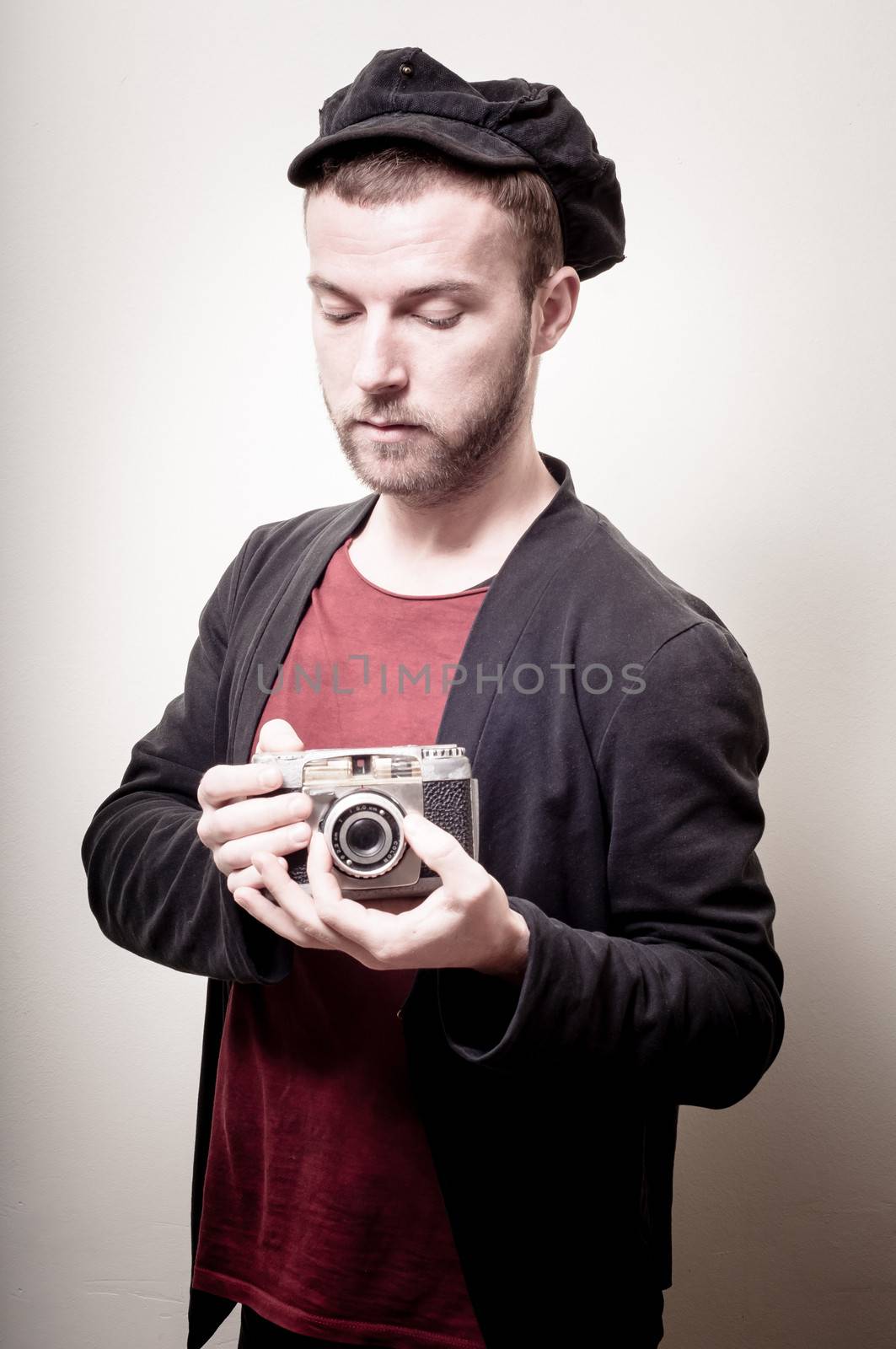 hipster stylish fashion man with old camera on gray background