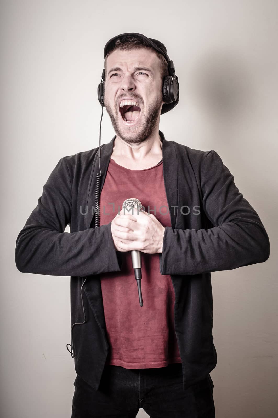 hipster stylish fashion blonde man with headphones on gray background