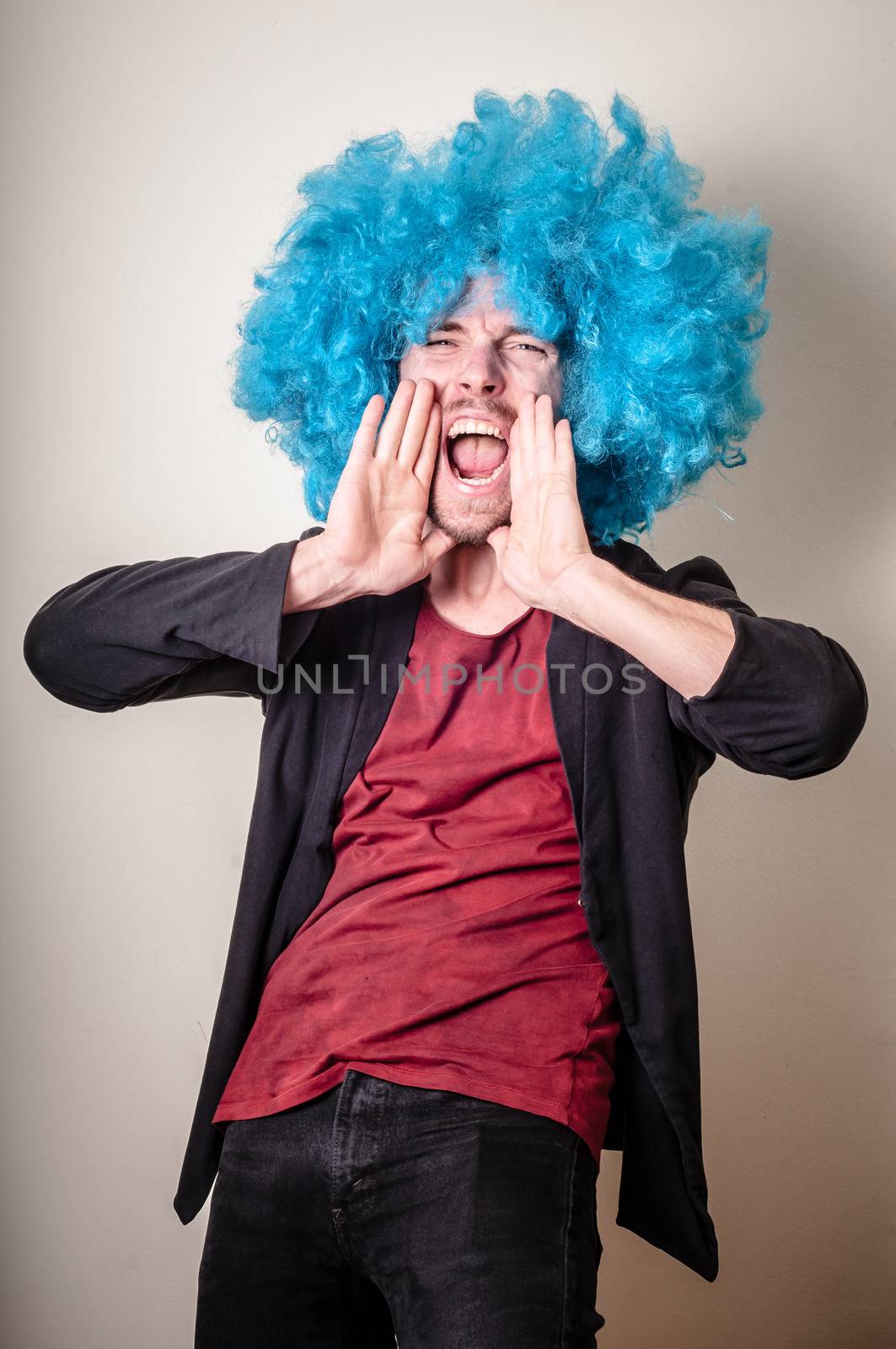 hipster stylish funny man with blue wig on gray background