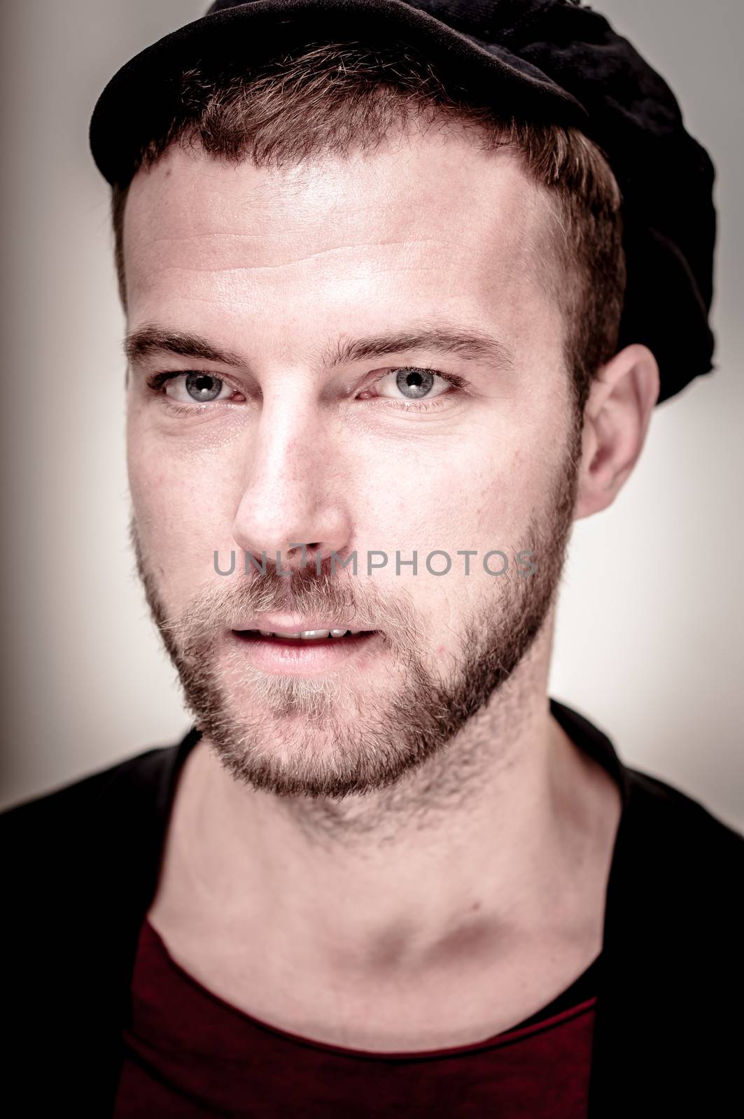 portrait closeup of hipster modern stylish blonde man on gray background
