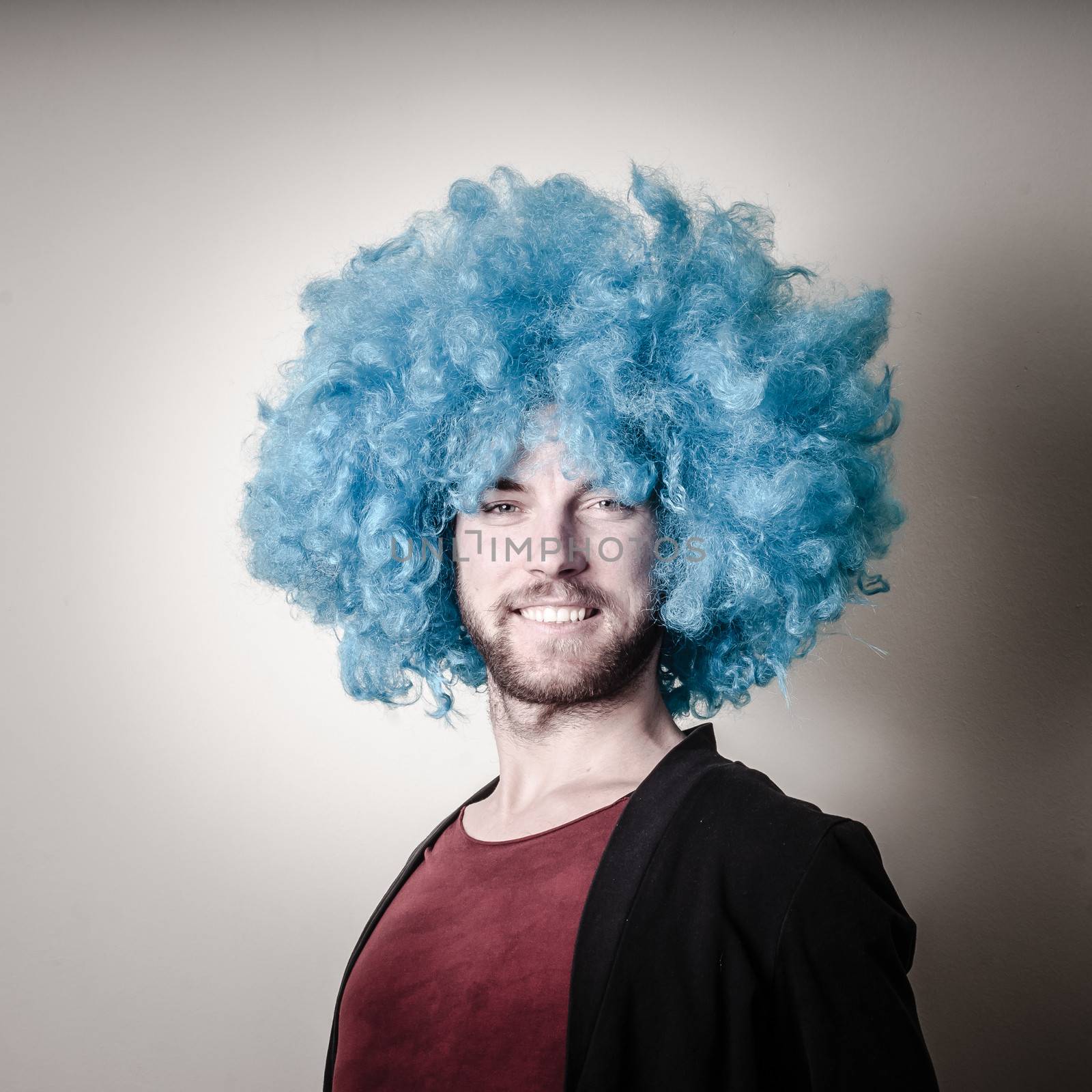 hipster stylish funny man with blue wig on gray background