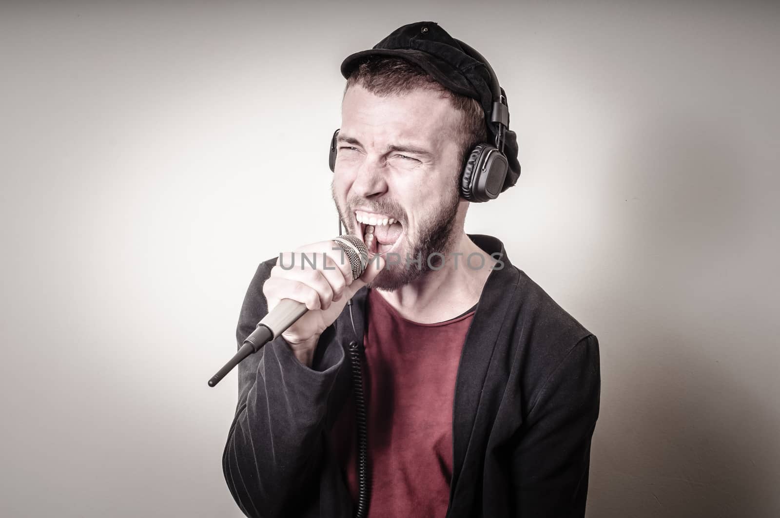 hipster stylish fashion blonde man with headphones on gray background