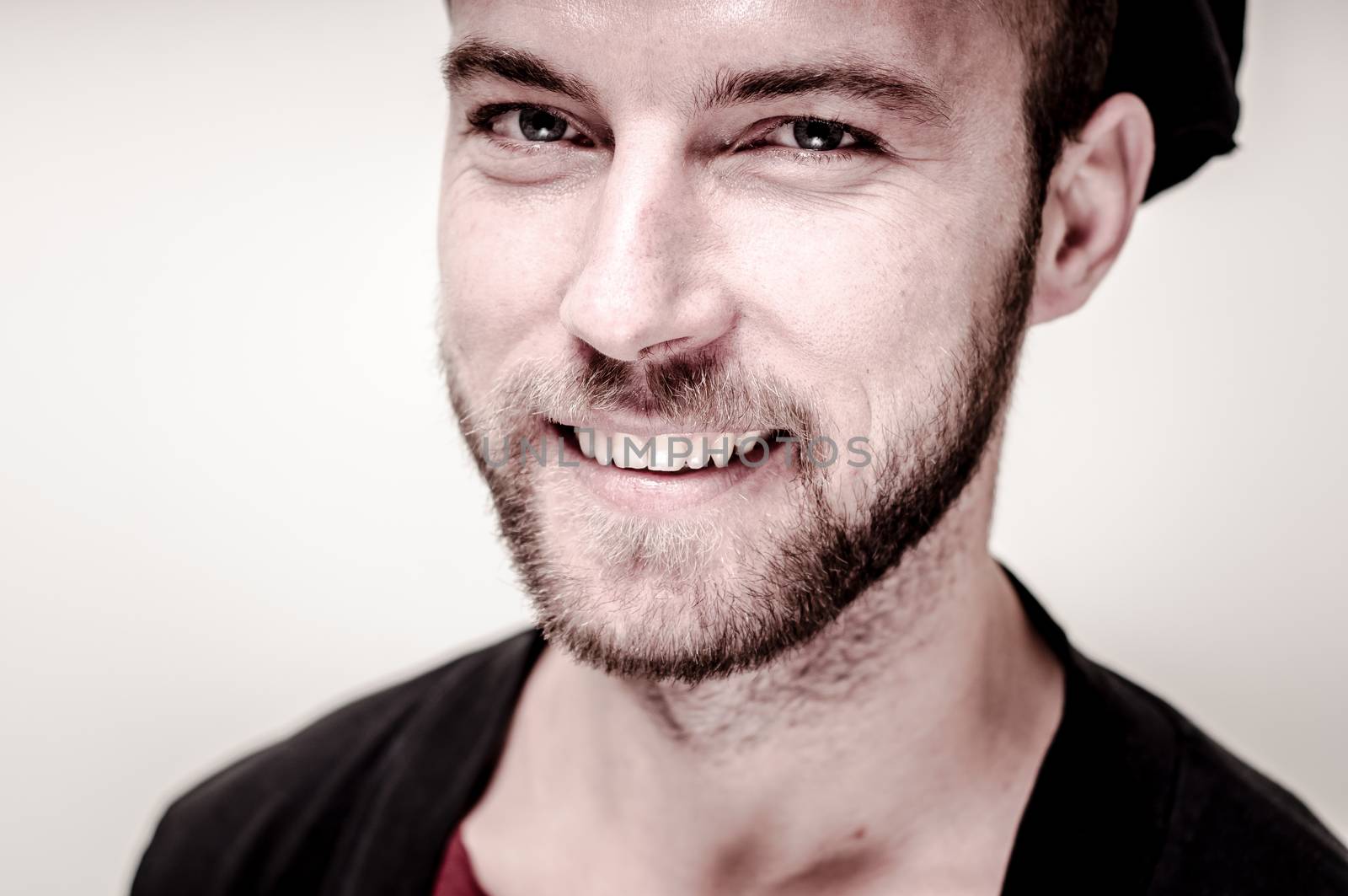 portrait closeup of hipster modern stylish blonde man on gray background