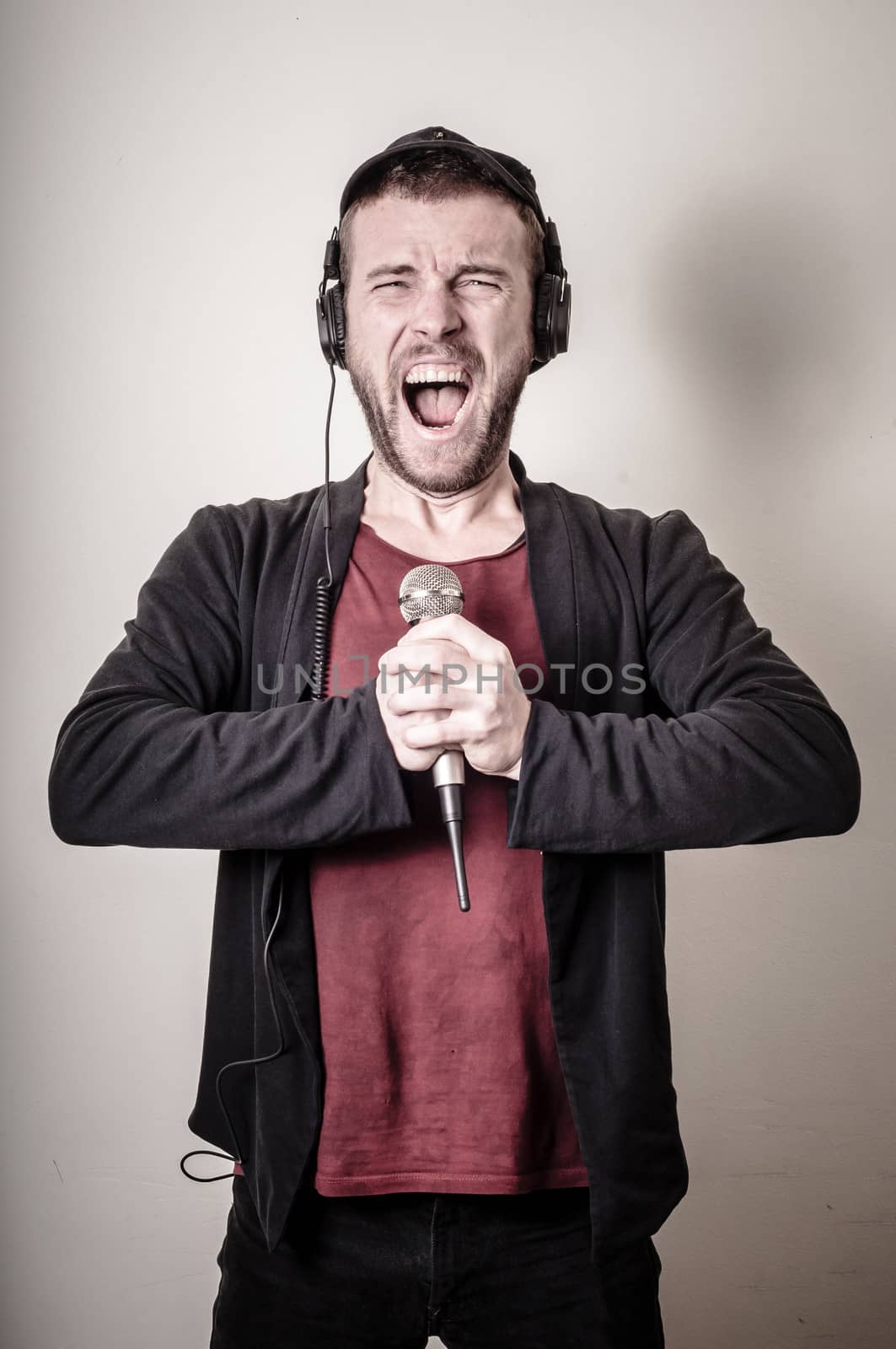 hipster stylish fashion blonde man with headphones on gray background