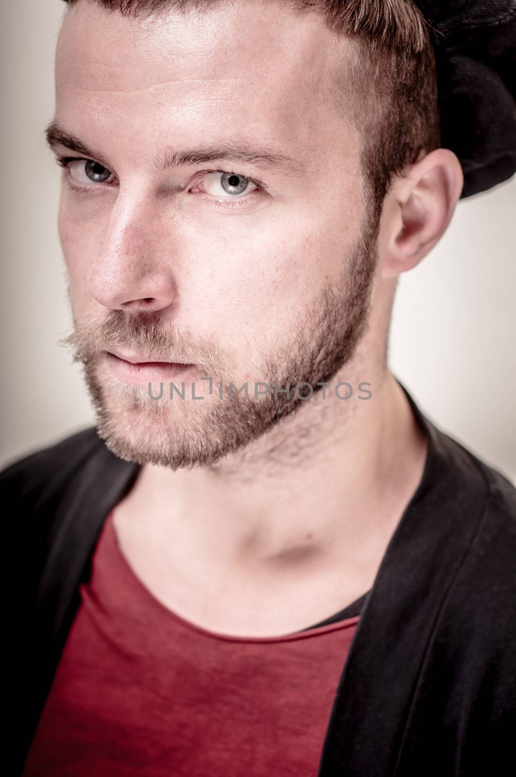 portrait closeup of hipster modern stylish blonde man on gray background