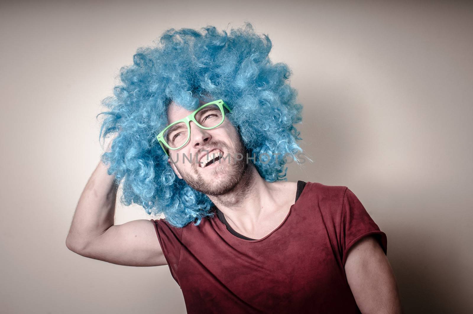 hipster stylish funny man with blue wig on gray background