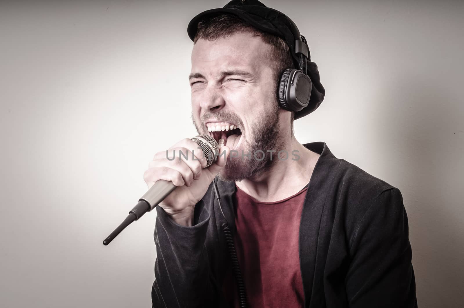 hipster stylish fashion blonde man with headphones on gray background