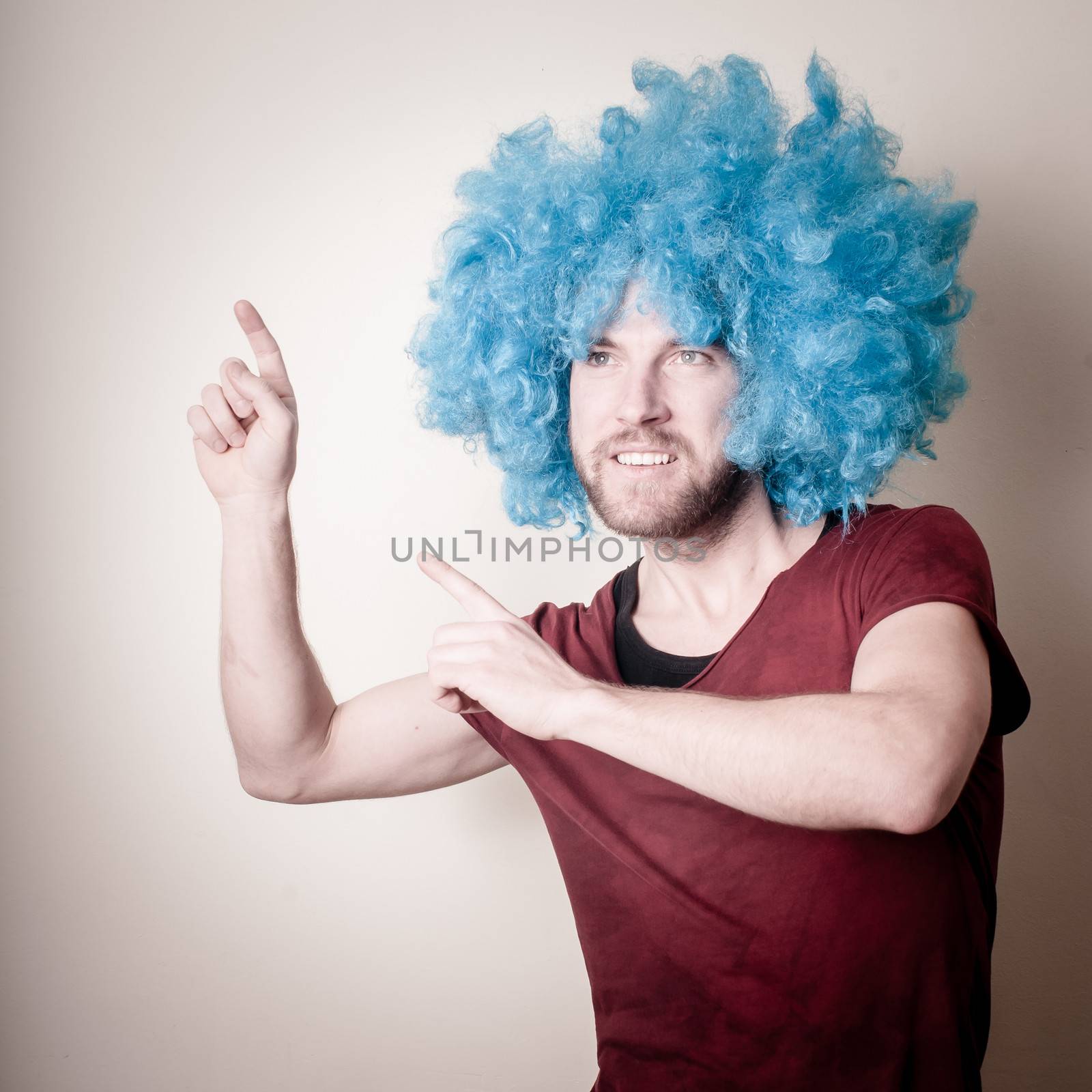 hipster stylish funny man with blue wig on gray background