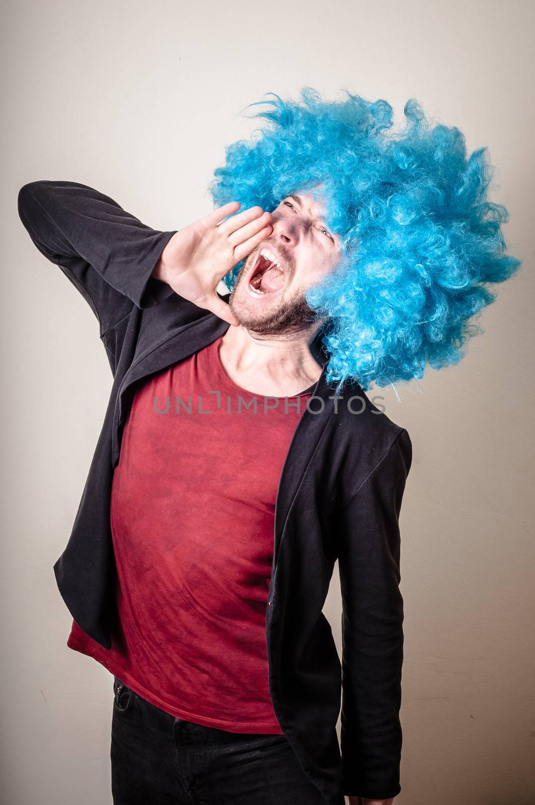 hipster stylish funny man with blue wig on gray background