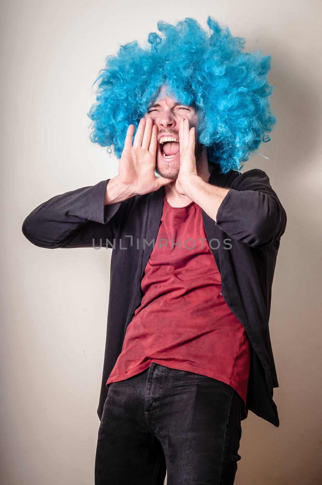 hipster stylish funny man with blue wig on gray background