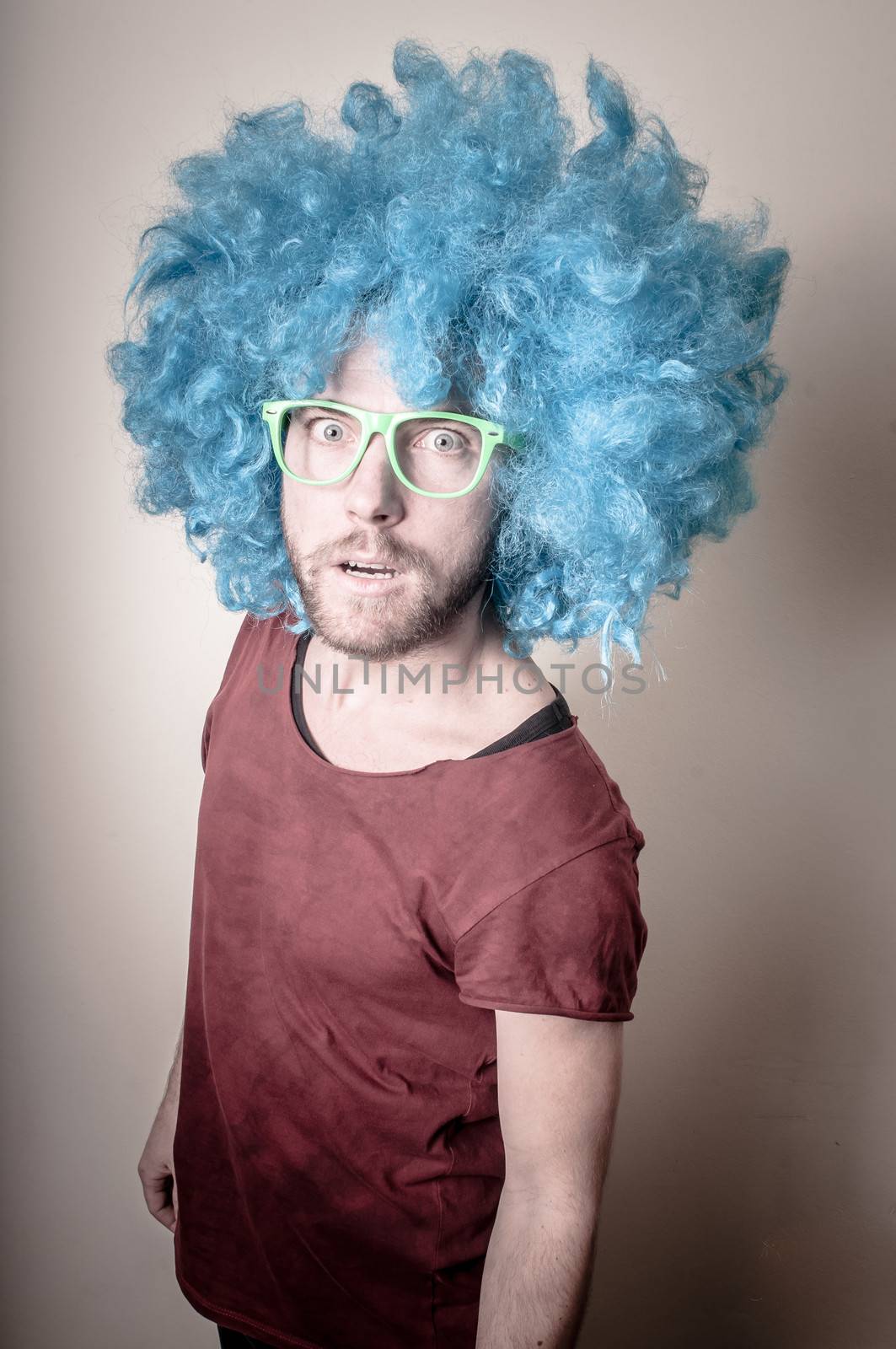 hipster stylish funny man with blue wig on gray background