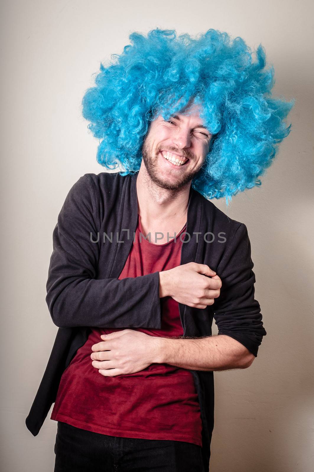 hipster stylish funny man with blue wig on gray background