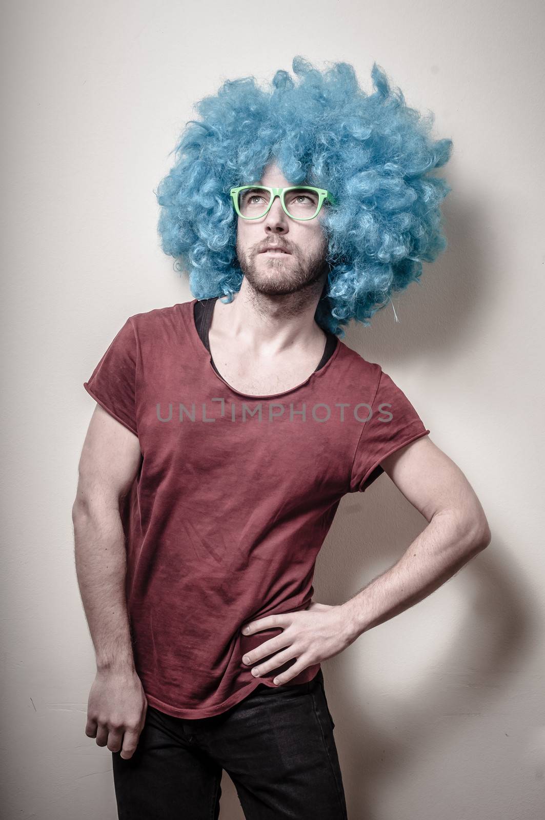 hipster stylish funny man with blue wig on gray background