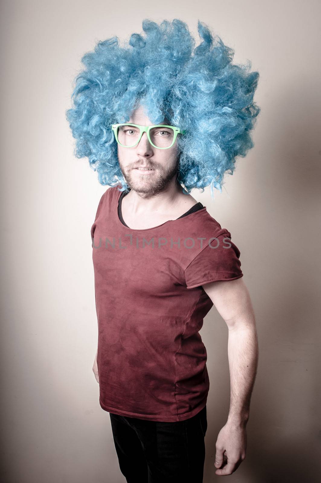 hipster stylish funny man with blue wig on gray background