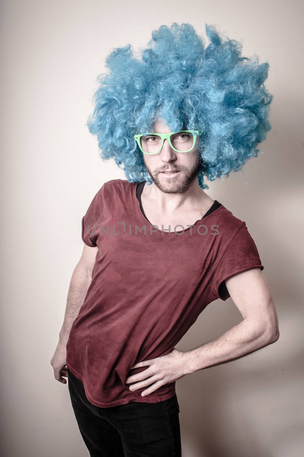 hipster stylish funny man with blue wig on gray background