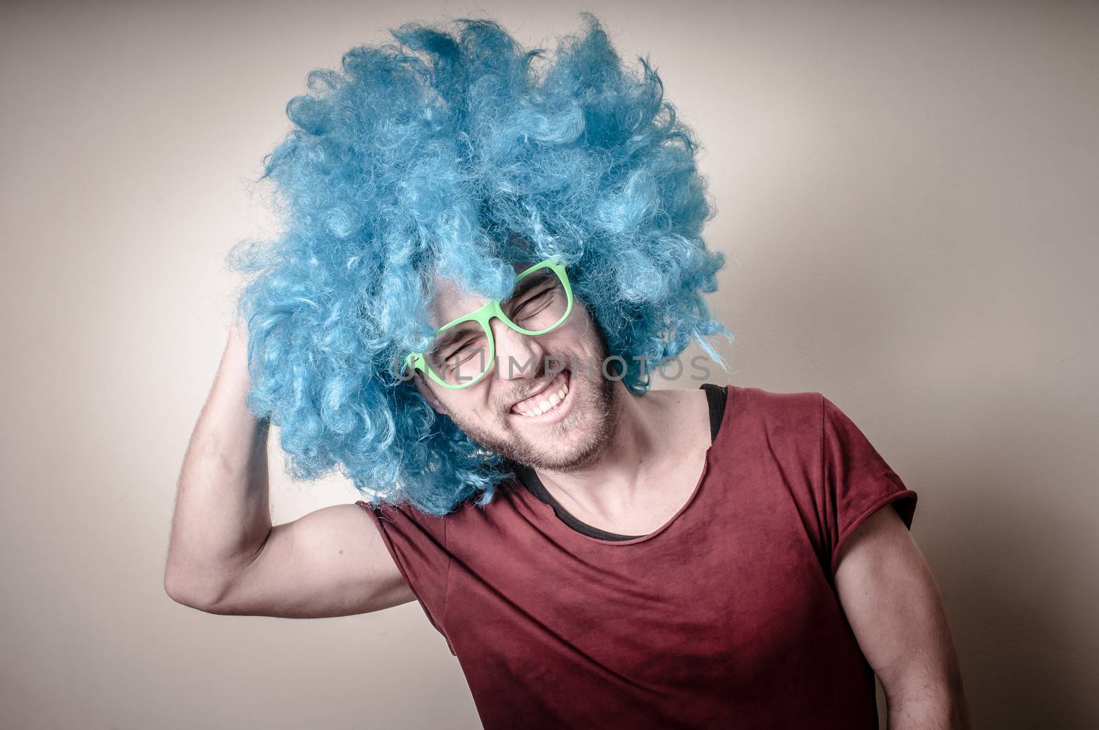hipster stylish funny man with blue wig on gray background
