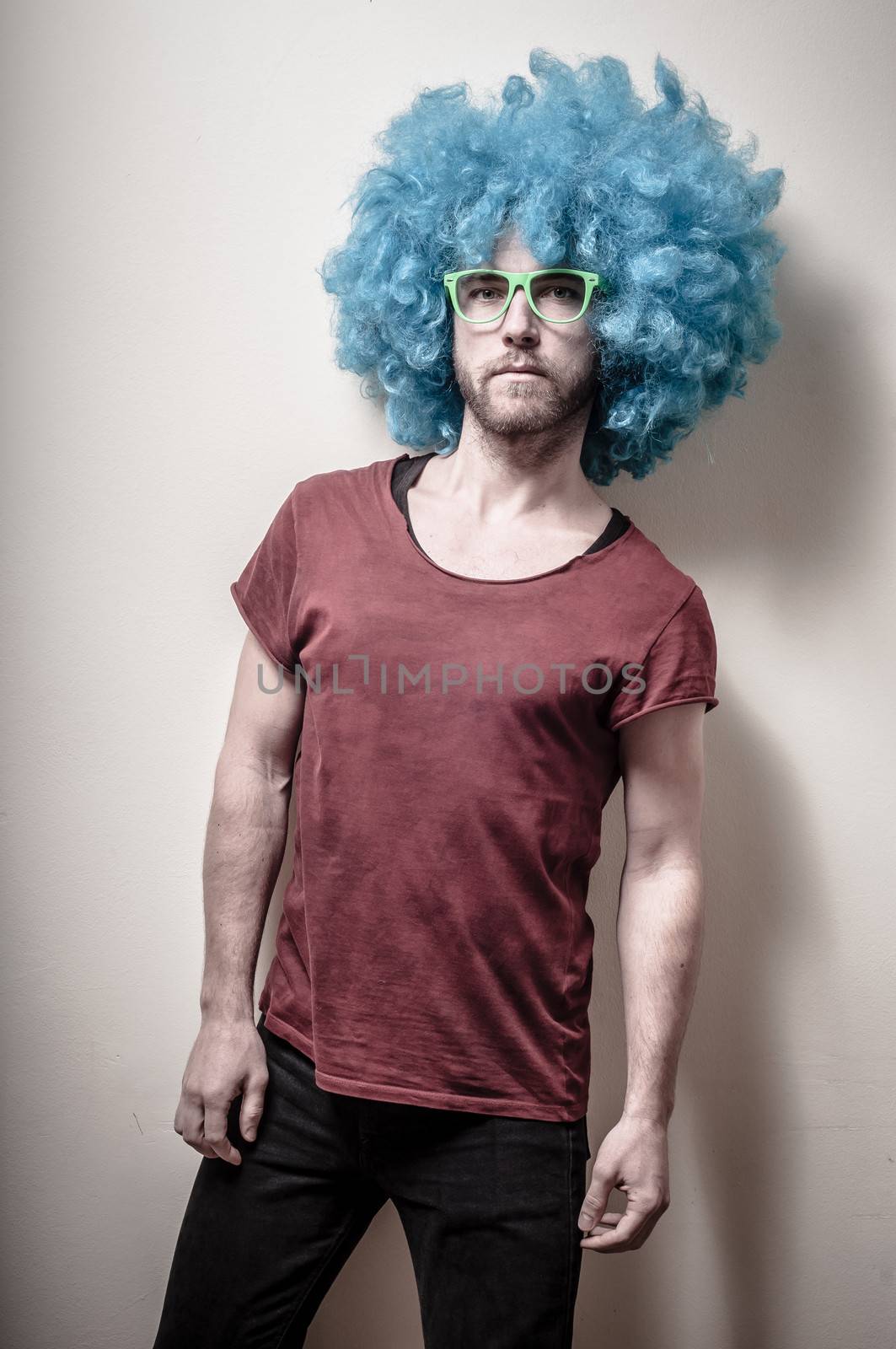 hipster stylish funny man with blue wig on gray background