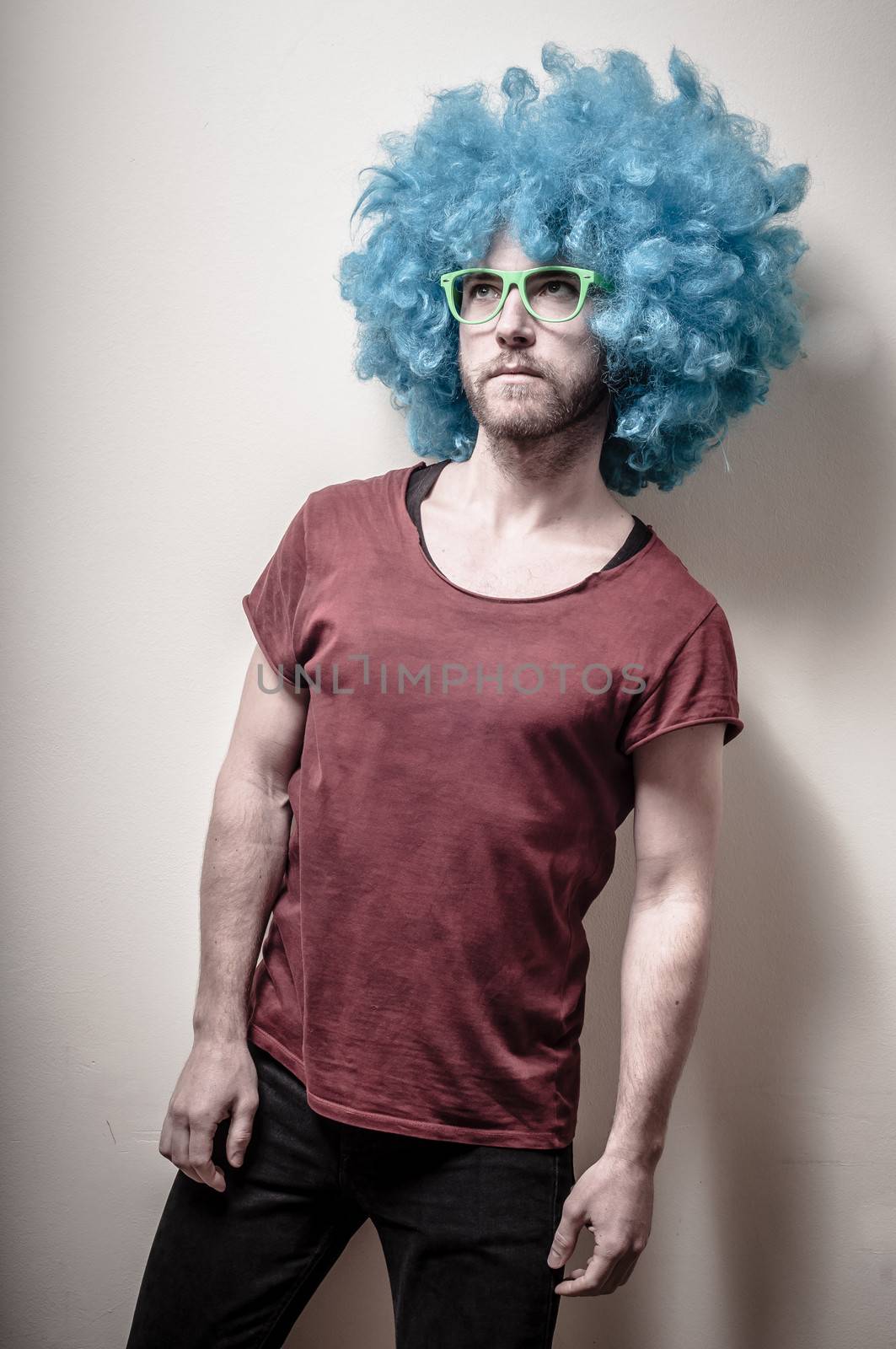 hipster stylish funny man with blue wig on gray background