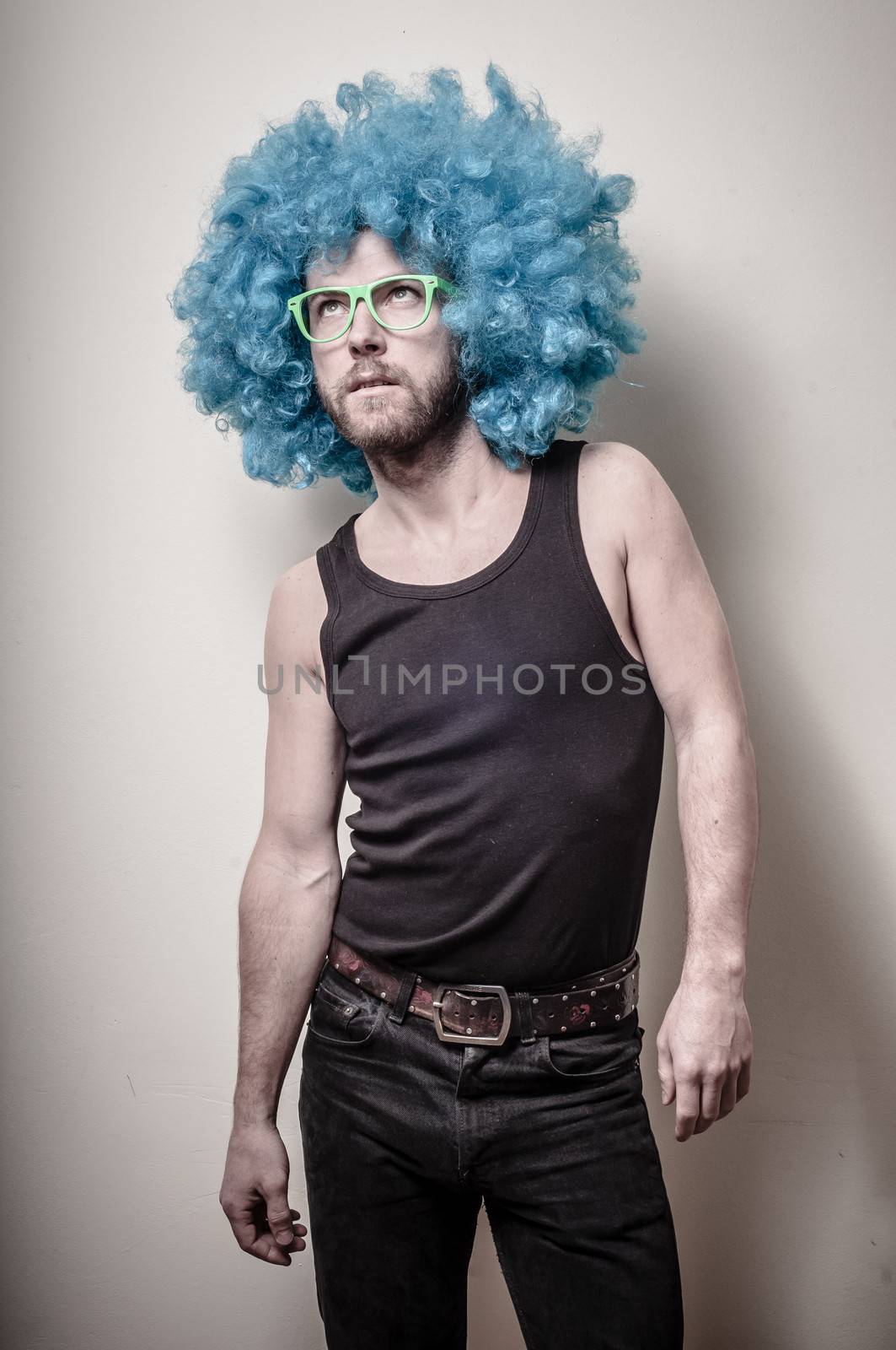 hipster stylish funny man with blue wig on gray background