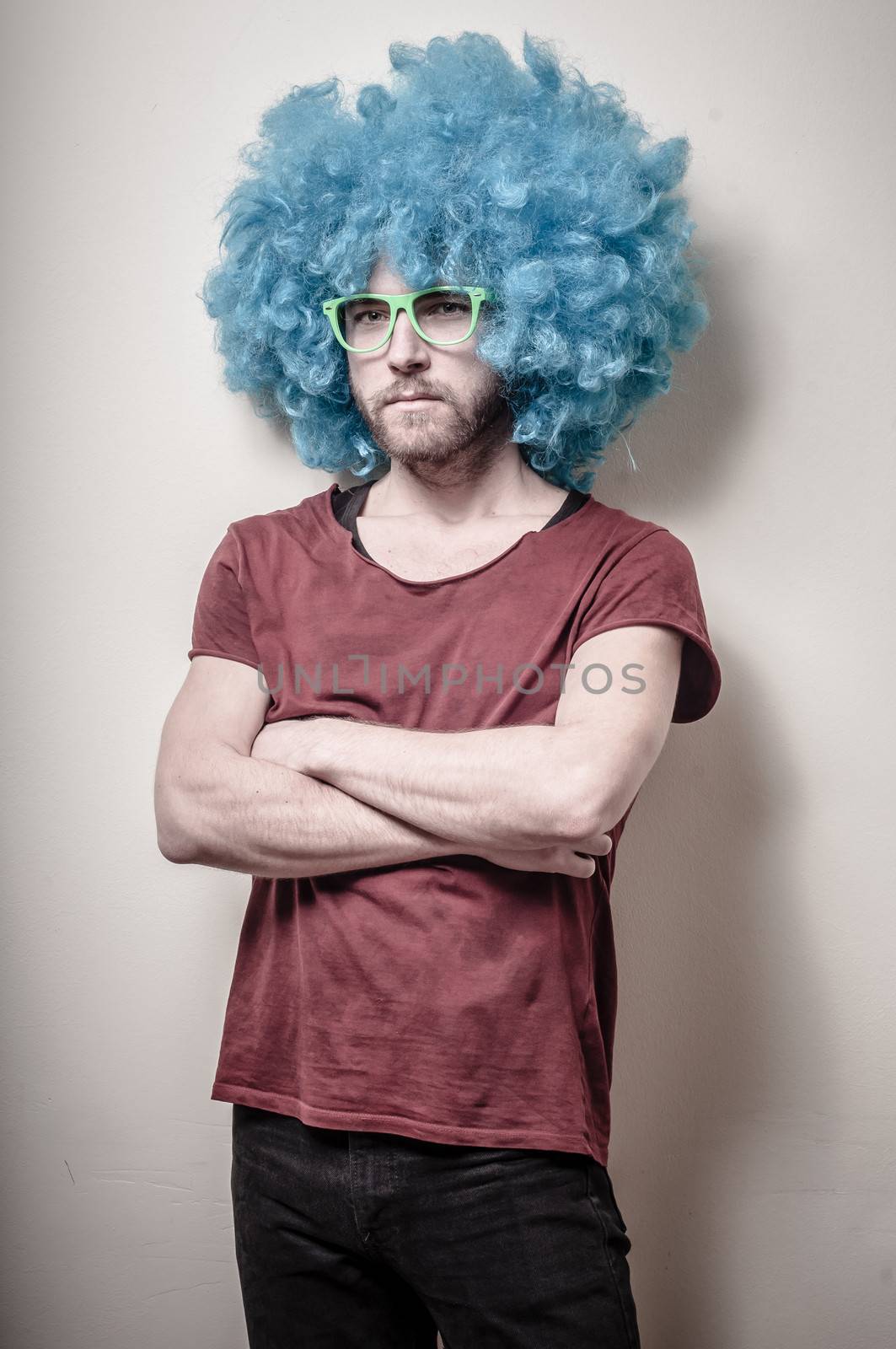 hipster stylish funny man with blue wig on gray background