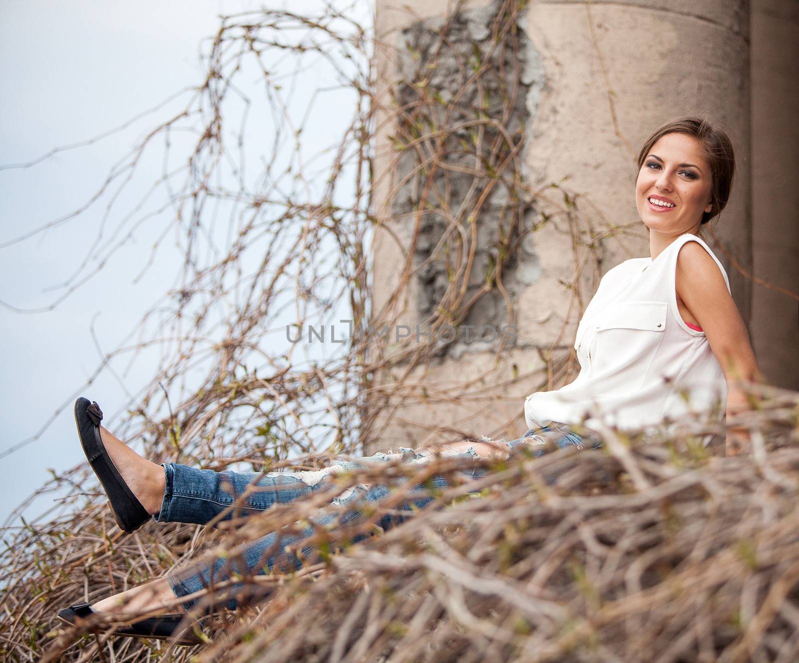 Beautiful young caucasian woman sitting in old vine