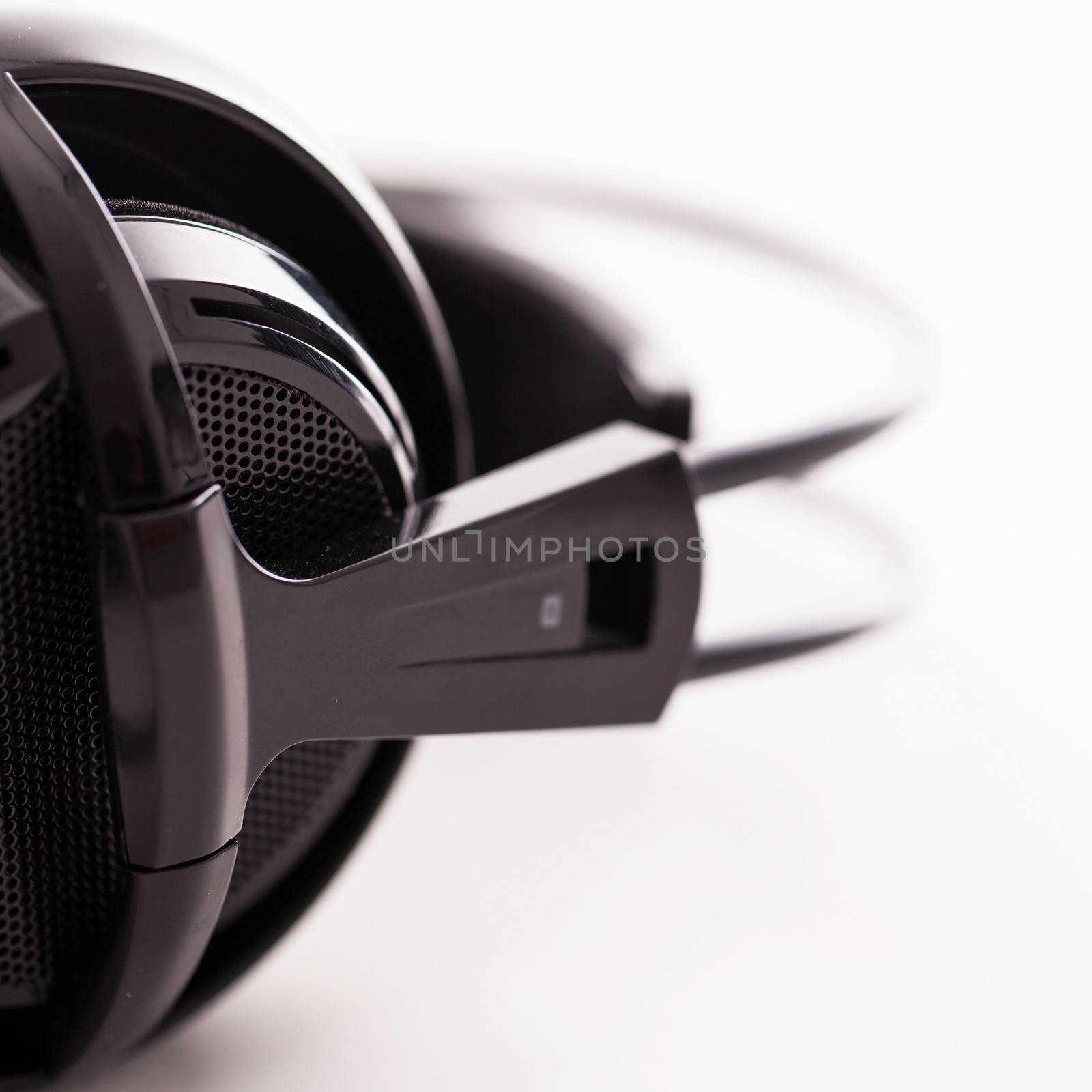 Closeup image of big black headphones on a white background