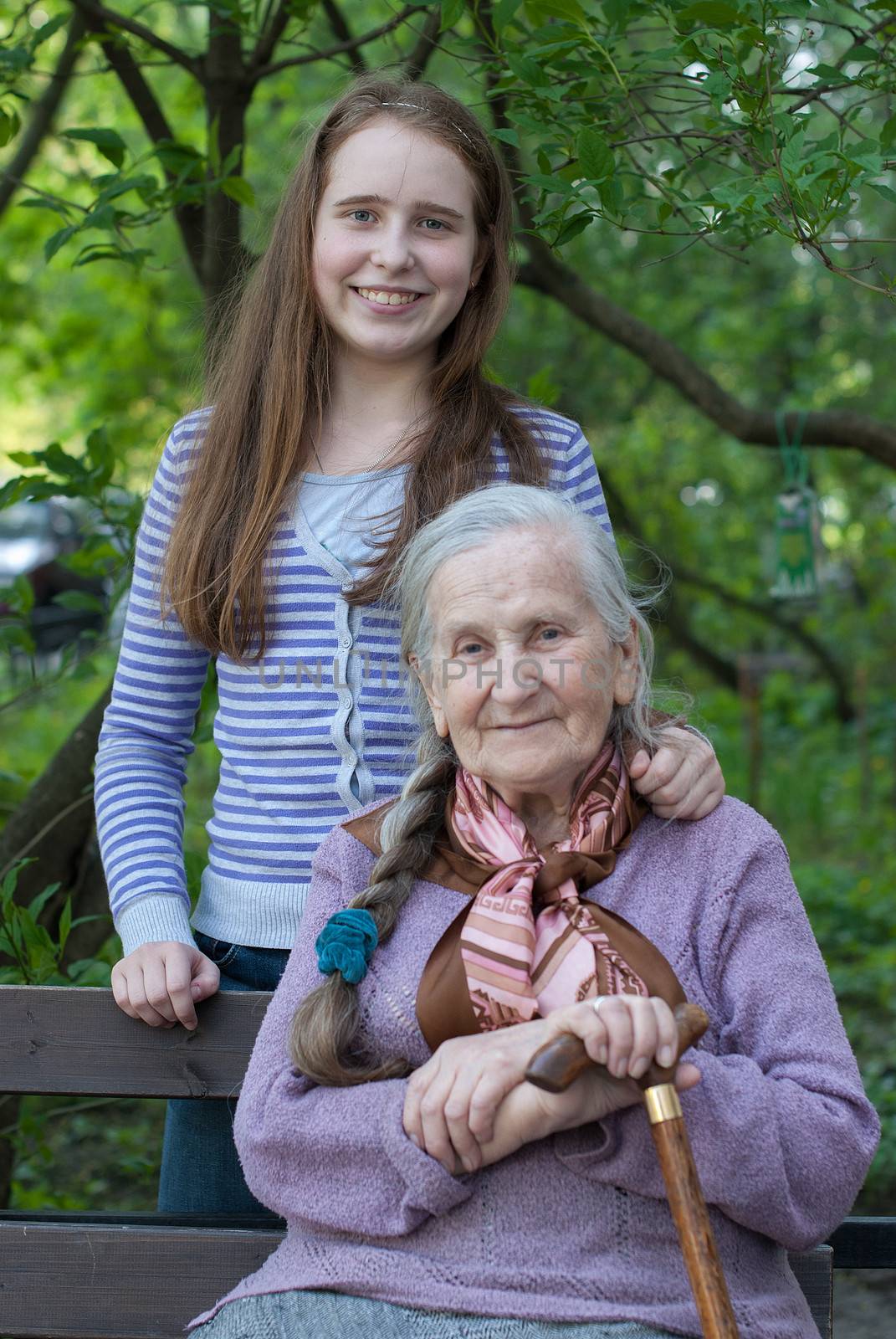 Grandmother and granddaughter laughing in the park in summer