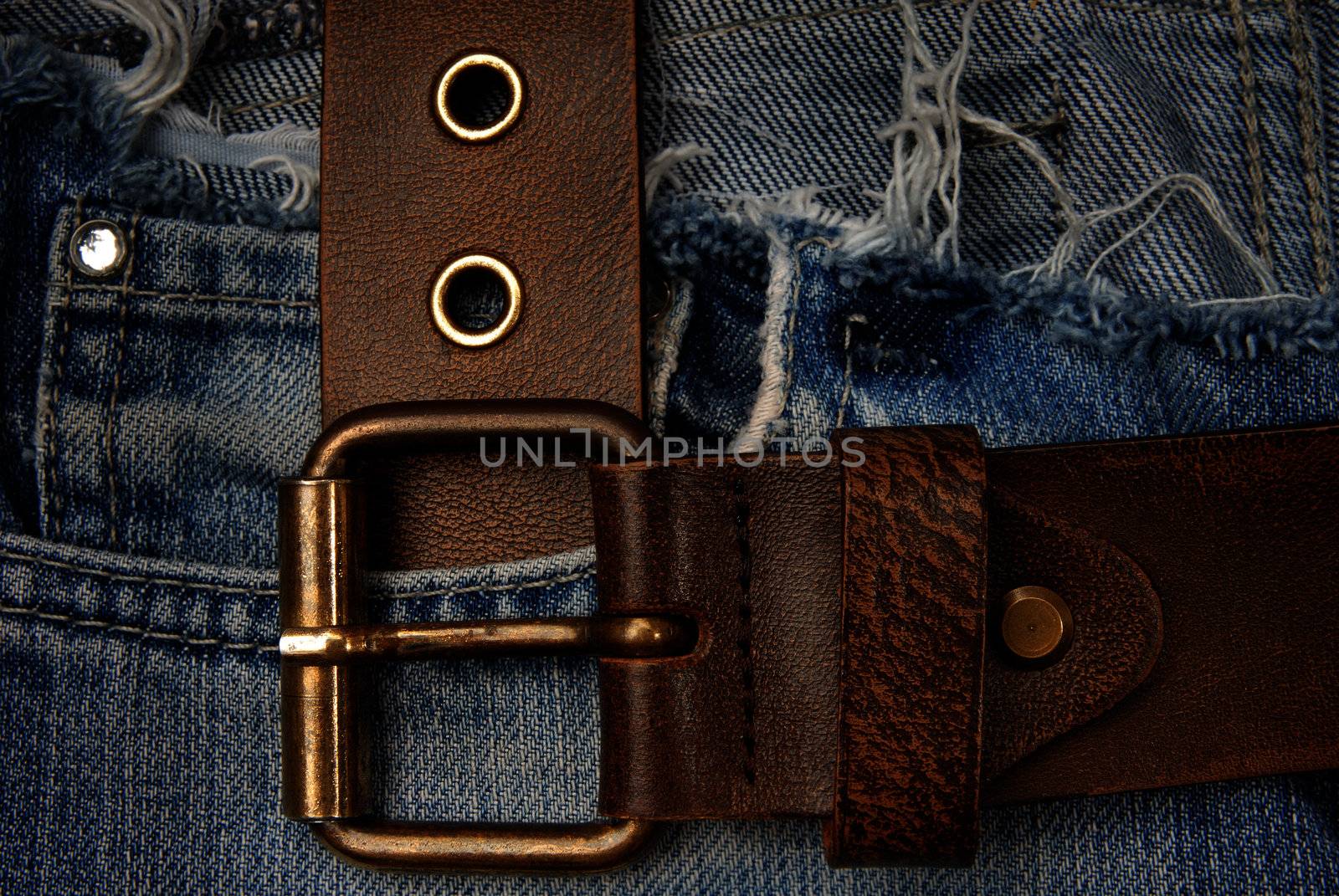 Close-up photo of the brown belt on old blue jeans