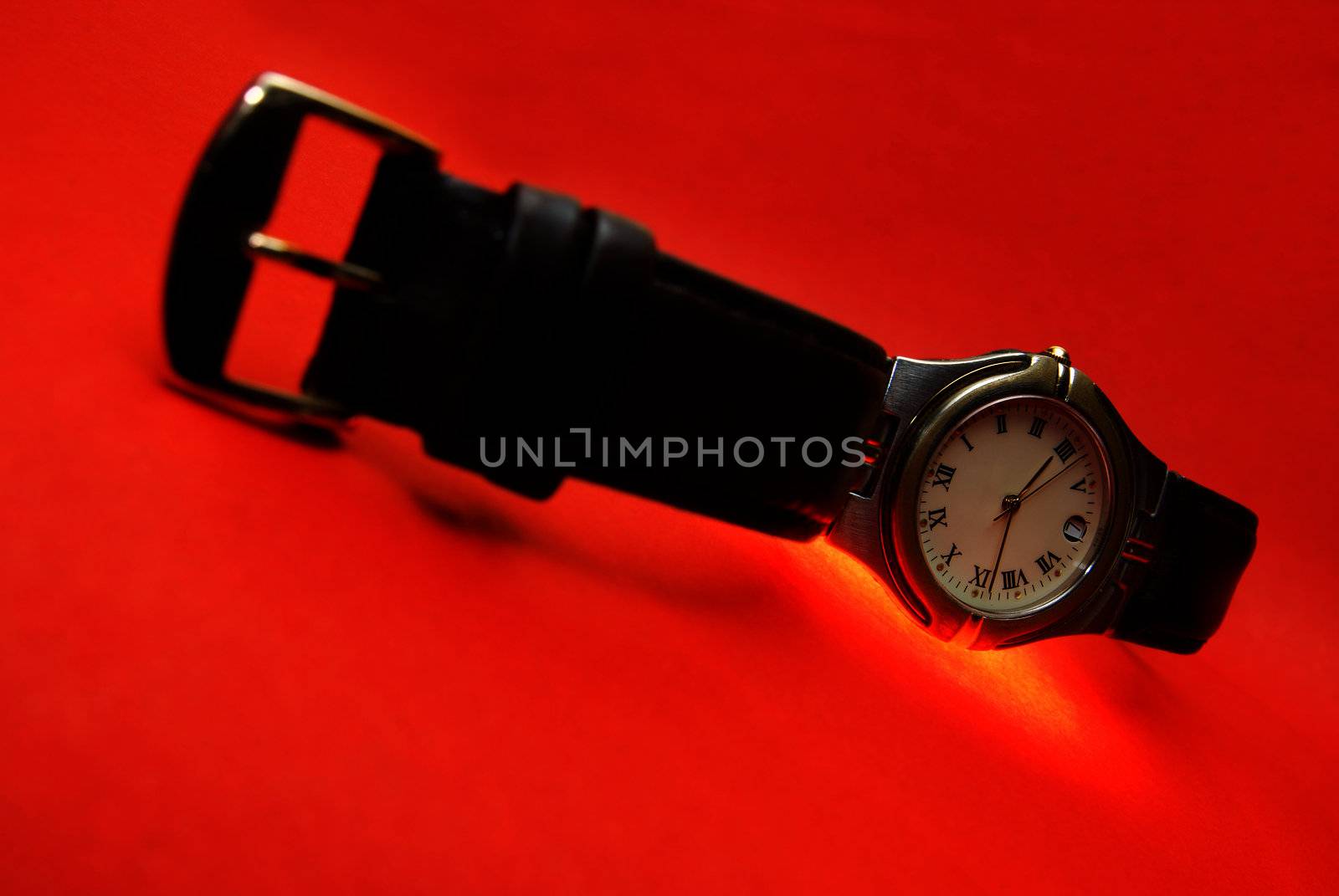 Silver watch with leather bracelet on a red background
