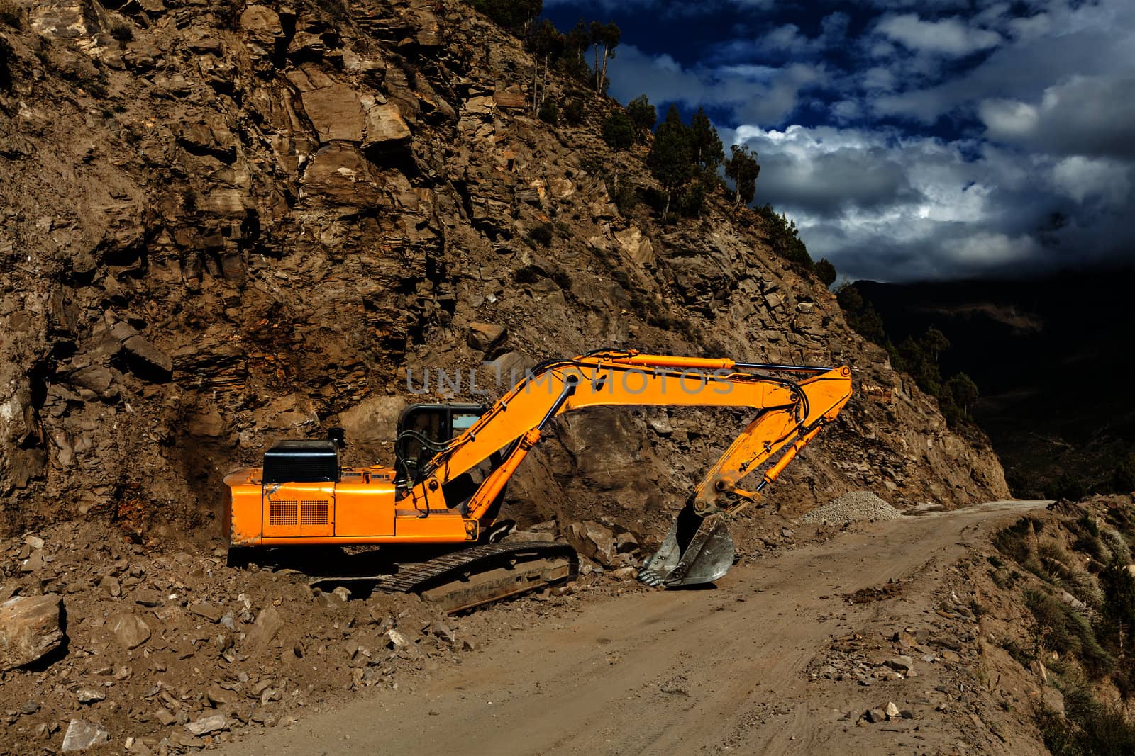Road construction in mountains Himalayas - excavator. Lahaul valley, Himachal Pradesh, India