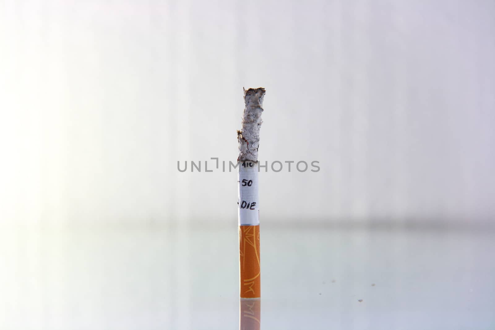 cigarette burning in front of white background