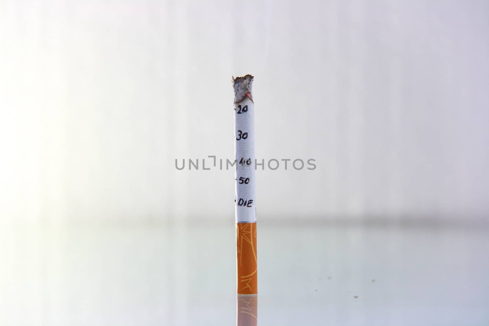 cigarette burning in front of white background