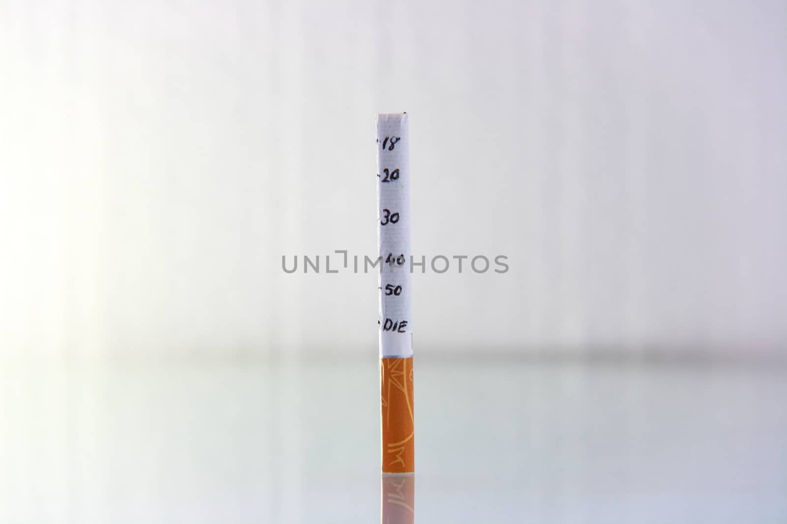 cigarette burning in front of white background