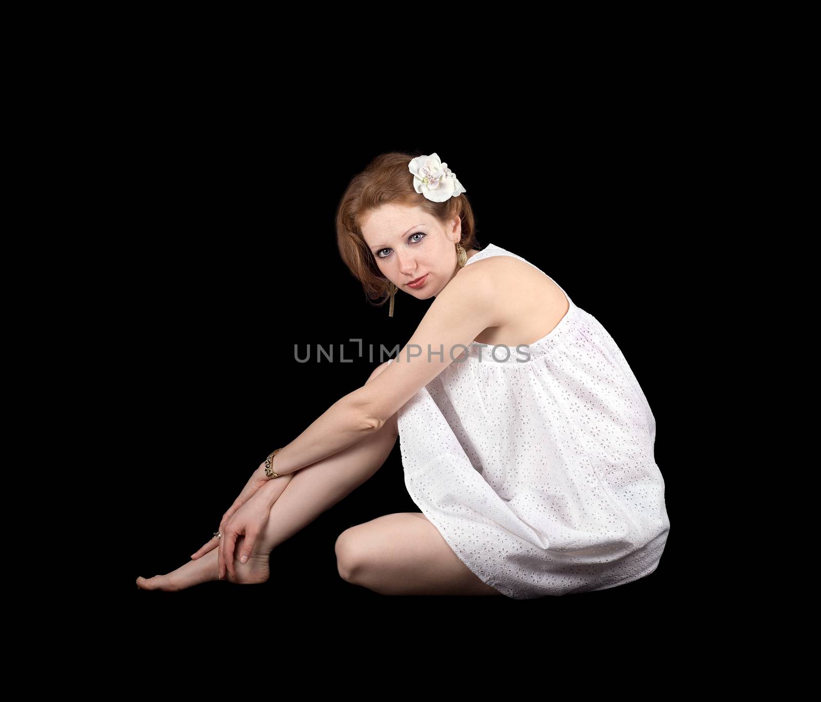 Red-haired girl with freckles in a white dress on a black background