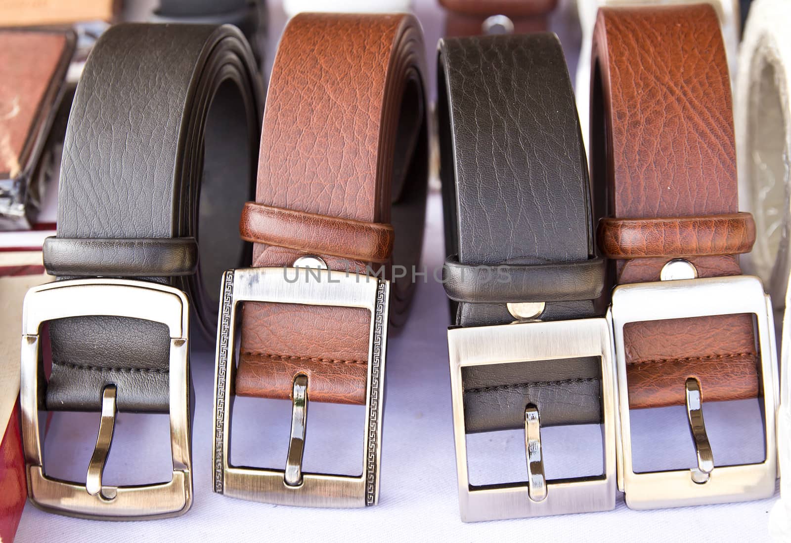 Closeup four leather belts on the table