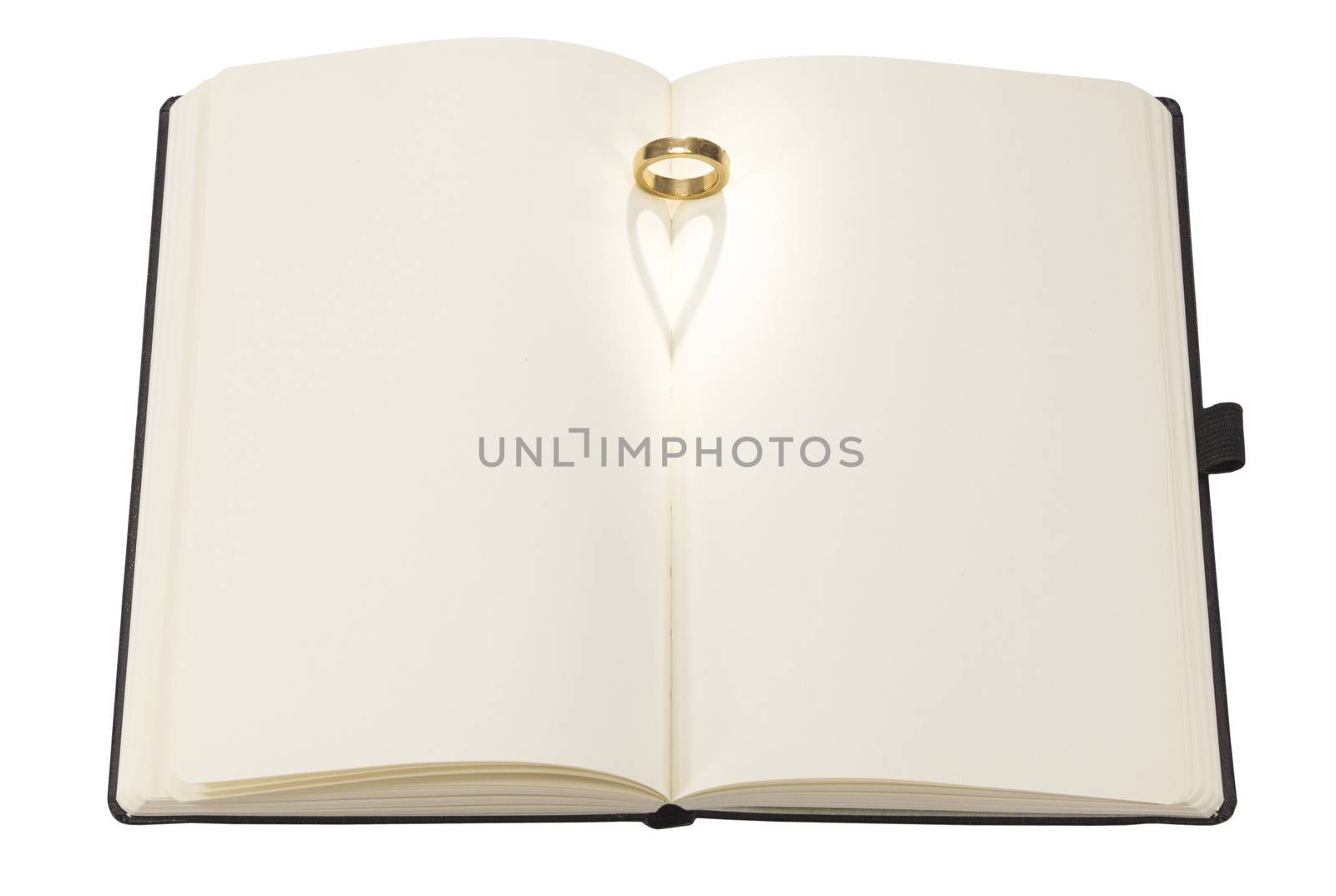 Heart shaped shadow of a ring on a book on white background
