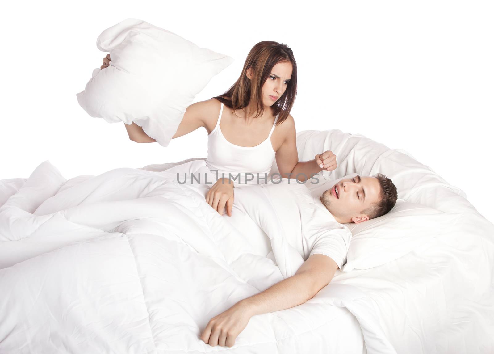 Frustrated wife trying to stop husband from snoring with pillow in bed, isolated.