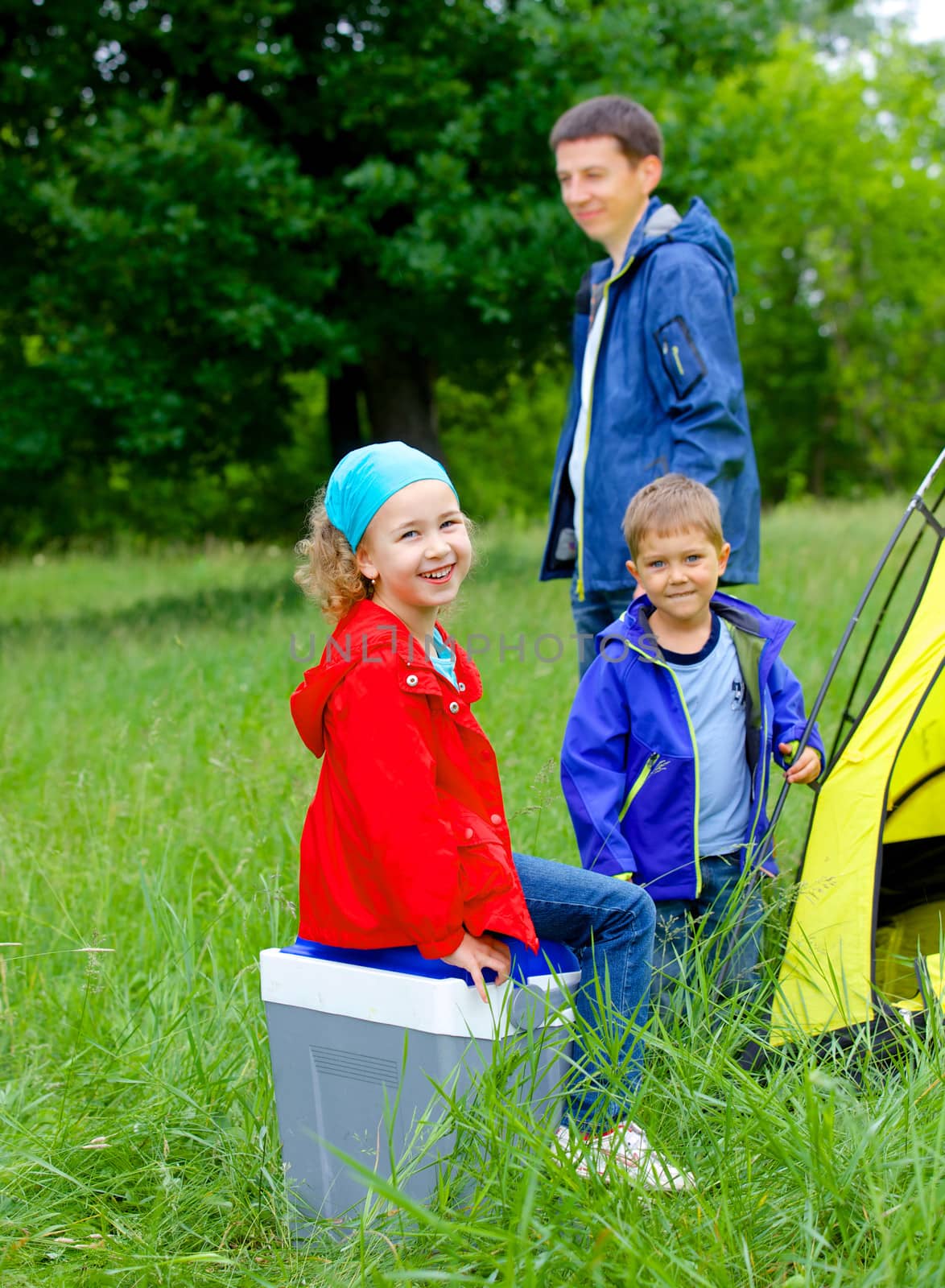 Summer, family camping - lovely sister and brother with father near camp tent. Vertical view