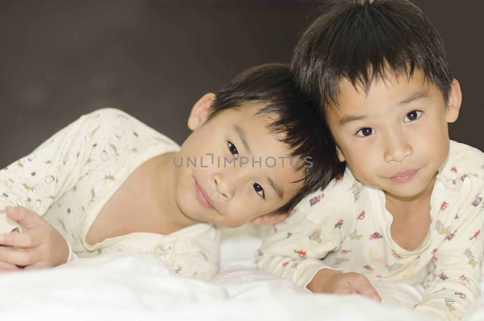 two twins brothers lying on bed