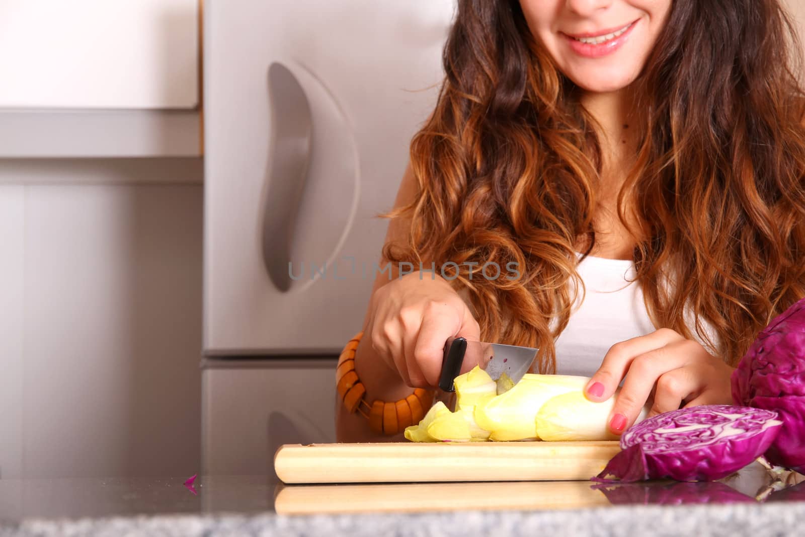 A young woman cutting vegetables.