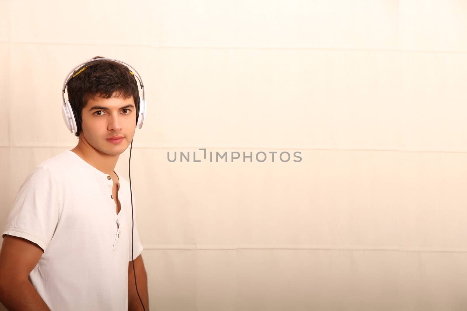 A young, latin man with a Tablet PC and headphones
