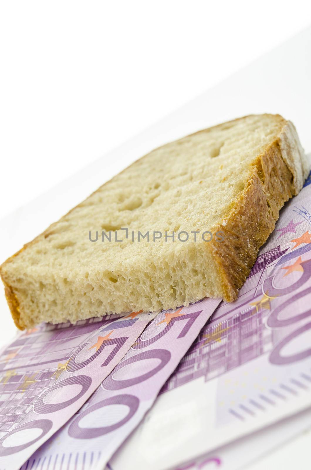 Piece of brad on Euro banknotes. Concept of large food expenses.