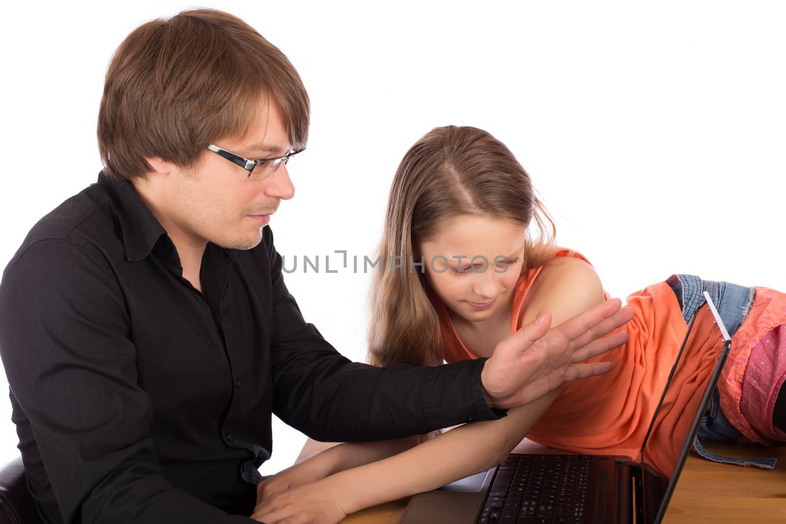 Father hides the screen of his laptop with his hand to his daughter who tries to watch what he do. Isolated on white background.