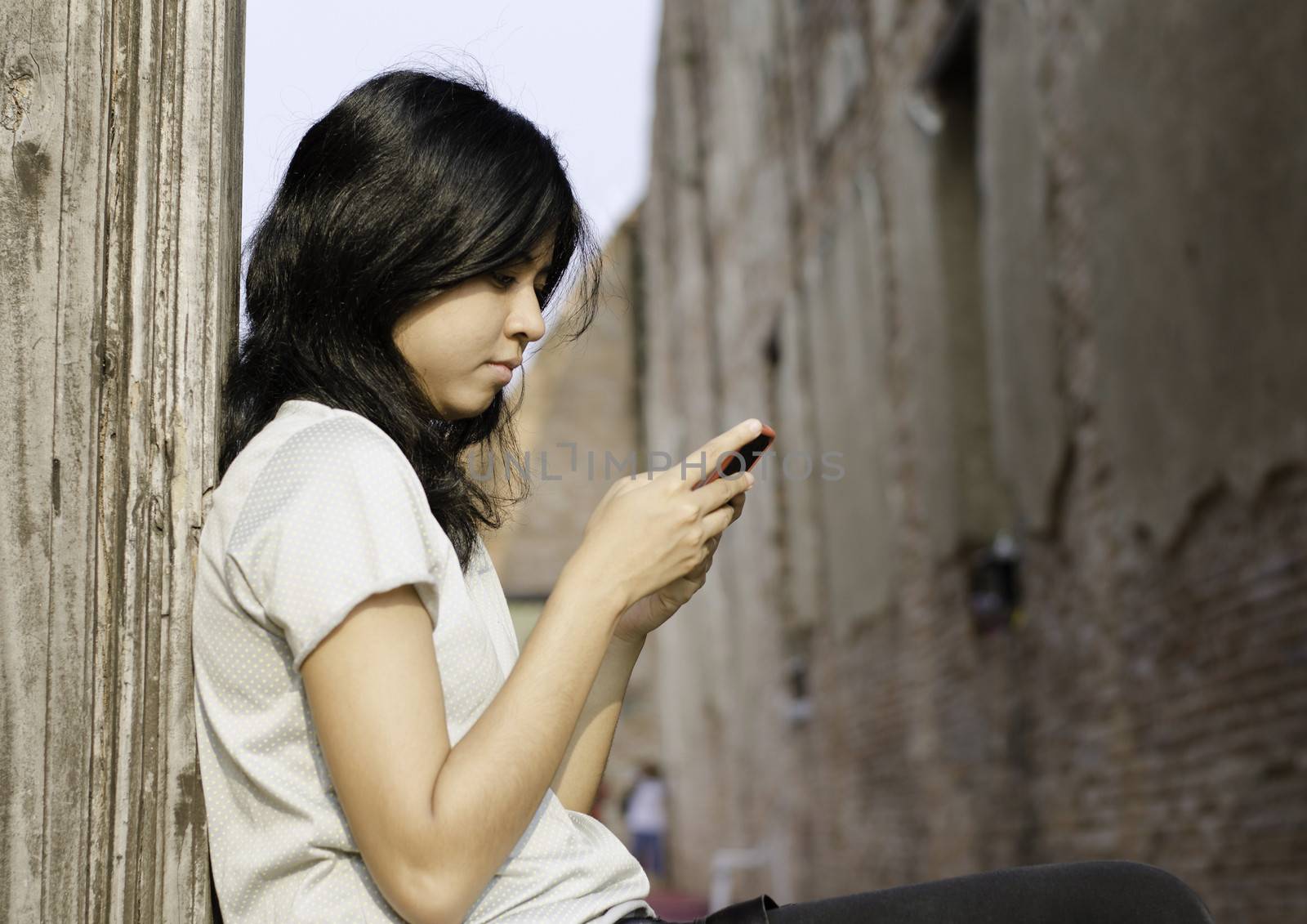 Young woman typing a message with someone on mobile phone