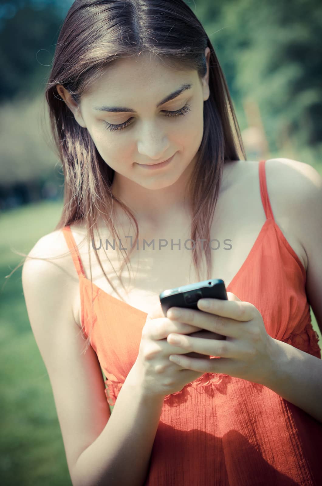 beautiful model young woman on the phone  in the park in spring