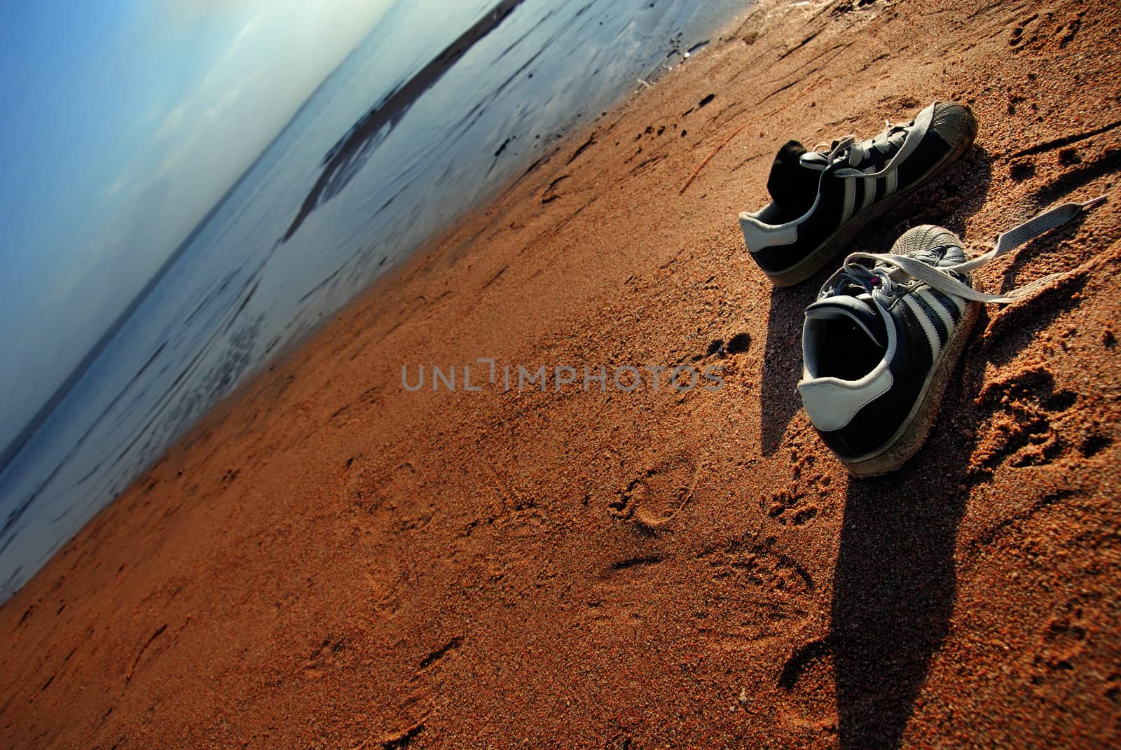 Two shoes of the traveller at the summer beach