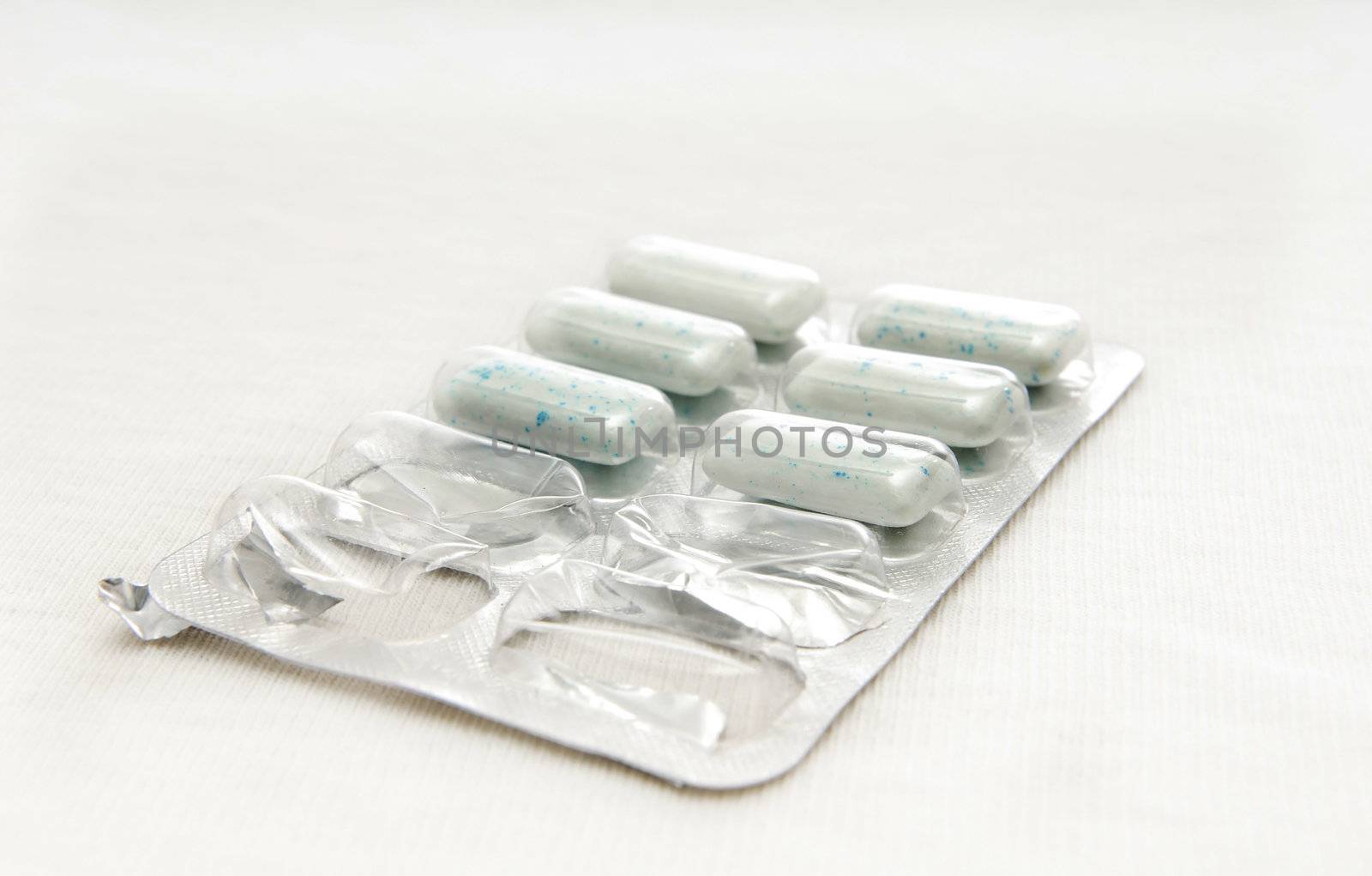 Close-up photo of bubble-gums or pills in package on a white background