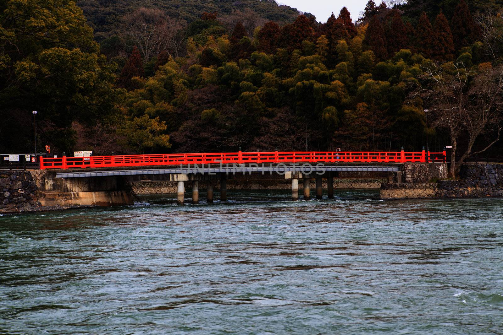 A red bridge over water by thanomphong