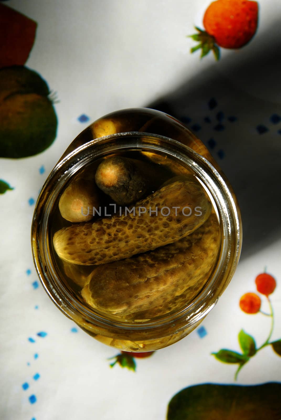 Close-up photo of pickling cucumbers on multi-colored table-cloth