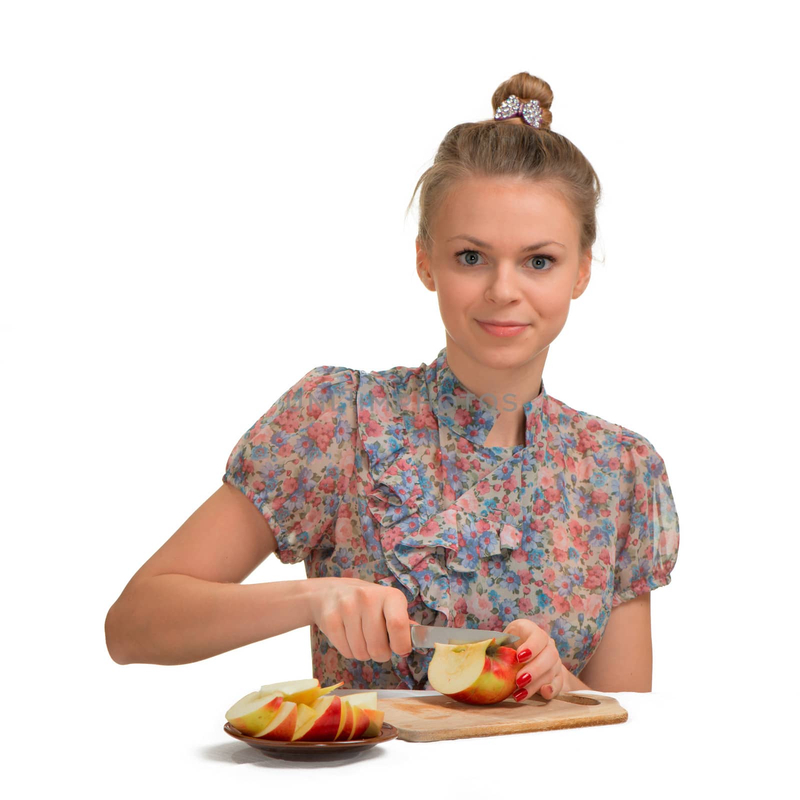 The beautiful girl the blonde cuts apples for pie in kitchen